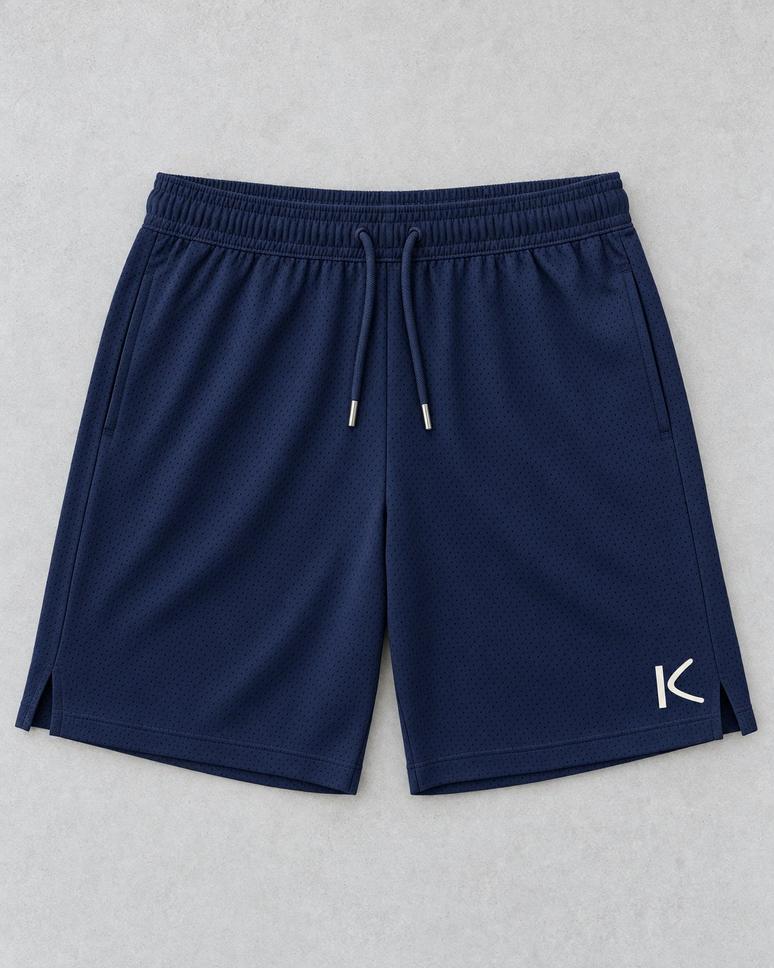 Navy Court Shorts laid flat, with a small chalk-white K on the leg.