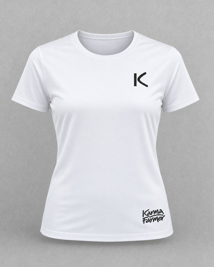 The white women's Court Tee from the front, with a small black K over the heart and a small Karma Farmer signature near the hem.