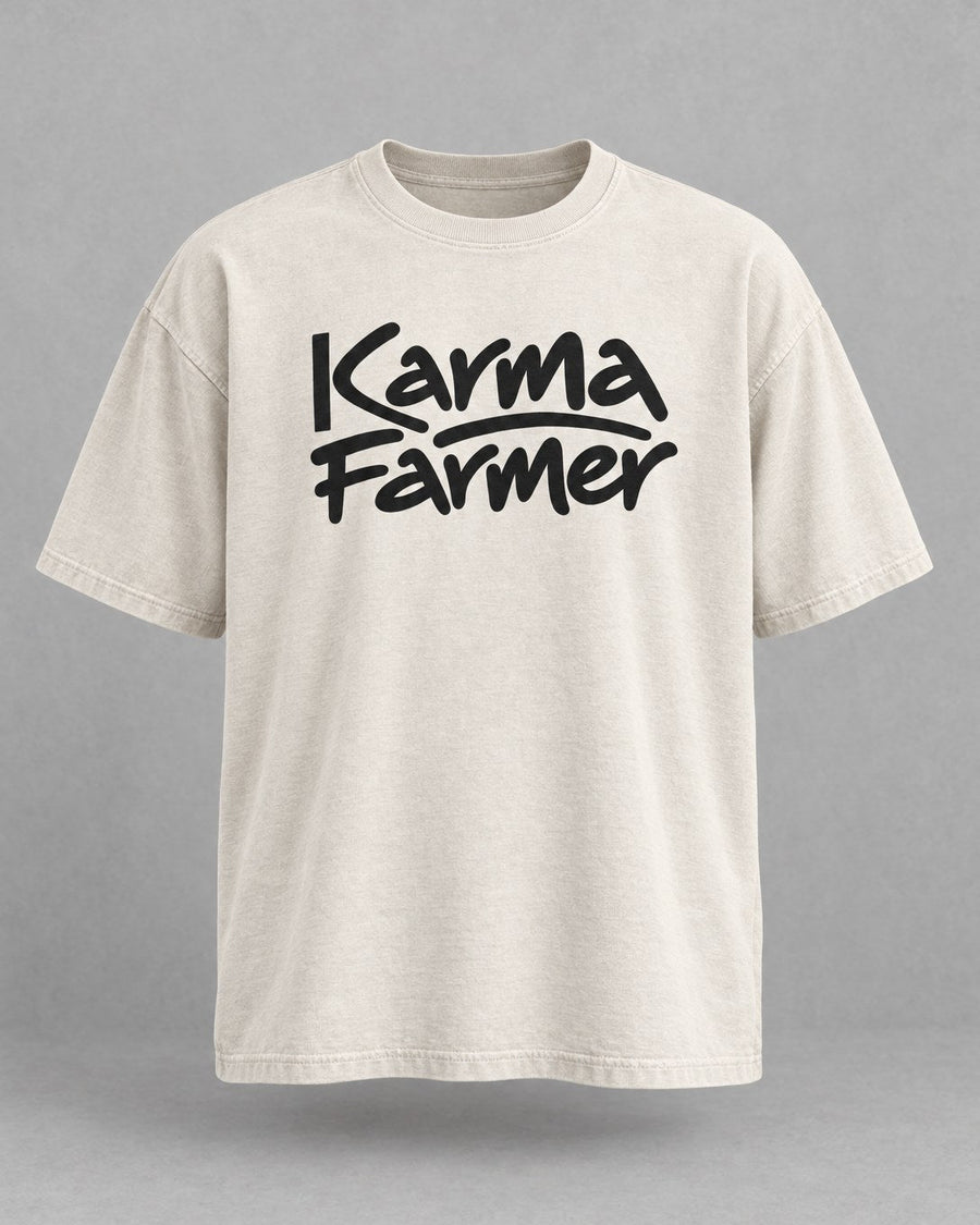 The bone Signature Tee from the front, with Karma Farmer across the chest in black marker lettering.